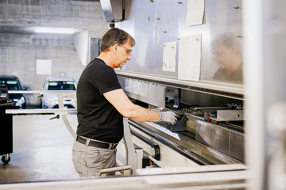 Sadat Ljazami an einer Abkantpresse, an der die zugeschnittenen Platten in die gewünschte Form gebogen werden.