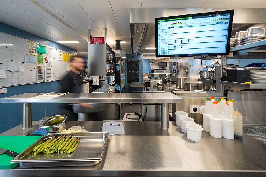 Moderne Technik: Auf dem Bildschirm sieht das Küchenteam jederzeit den Stand der Bestellungen, inklusive Zeitangabe.