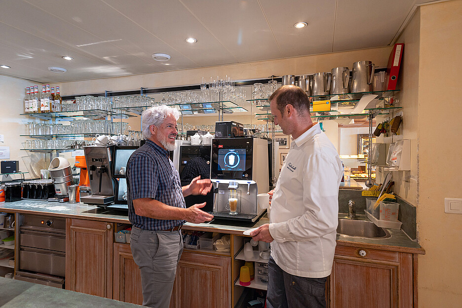 Rolph Müller, Gebietsverkaufsleiter der Cafina AG (l.) und Andreas Schaad, Geschäftsführer der Kaffeehalle, sind zufrieden mit dem neuen Kaffeevollautomaten XT8 von Cafina.
