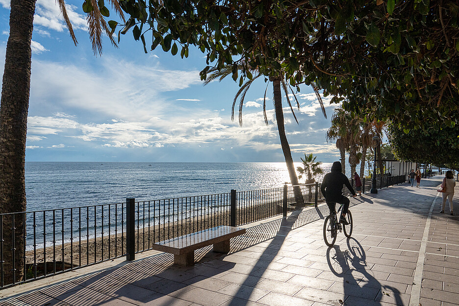Marbella Punkte von Menschen, kaum Figuren, vielmehr Farbflecke, die sich über die Promenade gleiten.
