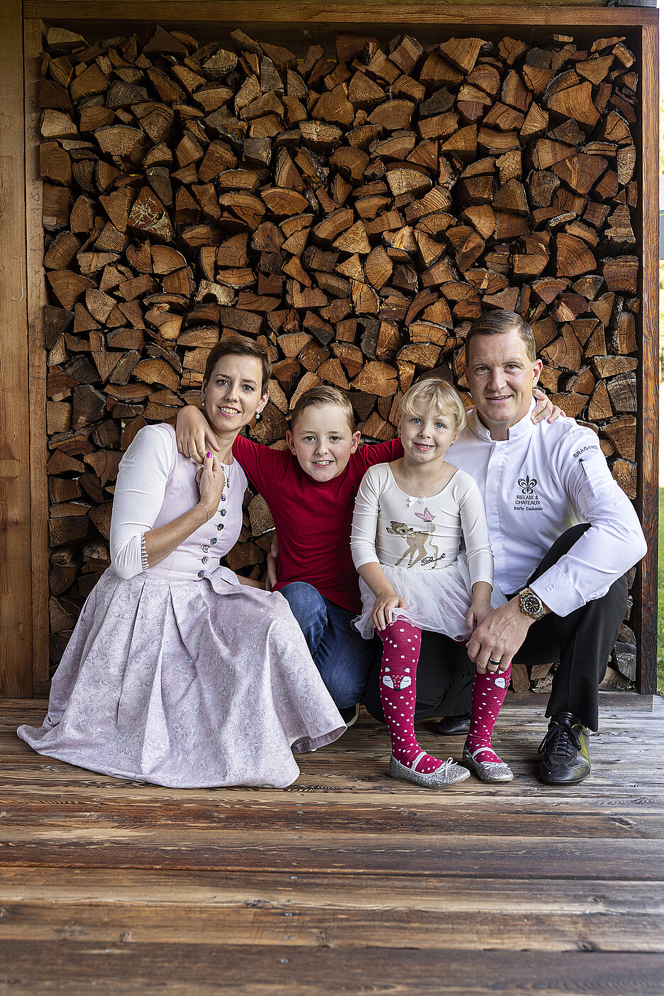 Familie Cadonau, umgeben vom prägenden und namensgebenden Material des IN LAIN: dem Holz.