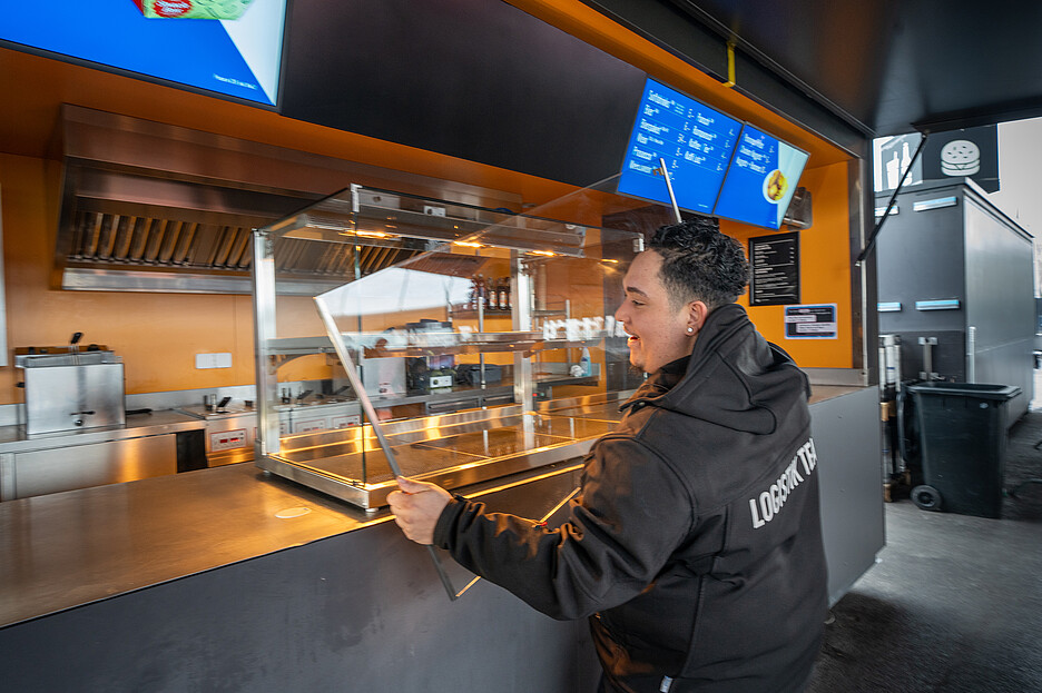 Die Glasscheiben des Hot Cubes lassen sich einfach reinigen und wieder zusammenbauen. Brandon vom Logistik-Team bereitet die Verkaufsstände vor.