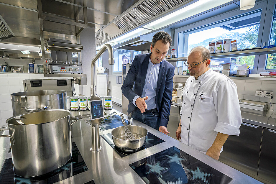 Adrian Seeholzer, Gebietsverkaufsleiter bei Menu System (l.) mit der State-of-the-Art-Herdanlage, mit der Küchenchef Patrick Weber (r.) und sein Team seit einem Jahr die Gäste der Residenz Am Schärme bekochen.