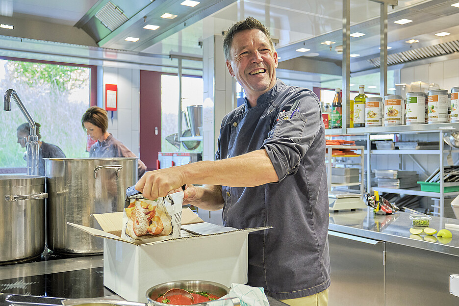 Küchenchef Markus Kappler mit einer frischen Lieferung der beliebten Delicool-Apfelküchlein.